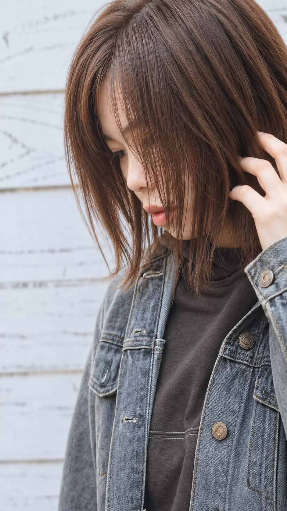ブラウンのミディアムヘアを自然な毛流れで仕上げた横顔のヘアスタイル